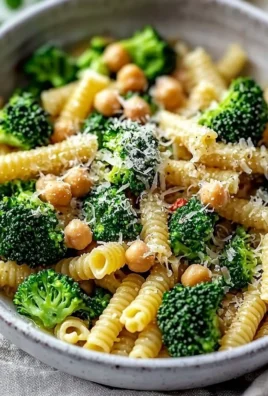 Broccoli chickpea pasta dish drizzled with garlic olive oil and garnished with herbs.