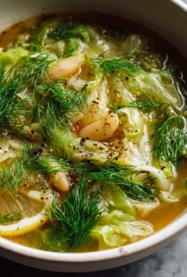 Bowl of delicious Lemon Dill Cabbage Soup garnished with fresh herbs