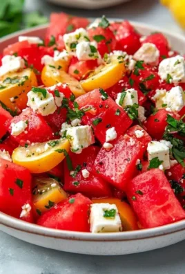 A colorful watermelon feta salad with mint and olive oil in a bowl.