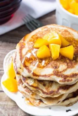 Delicious brown sugar peach pancakes served with fresh peaches and syrup