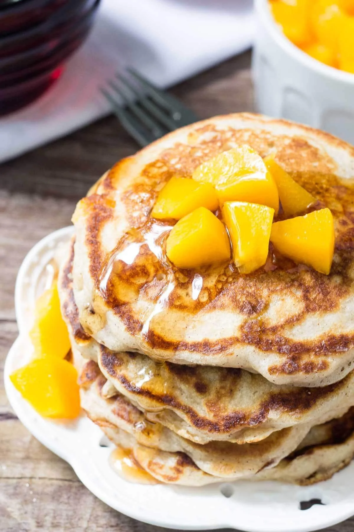 Delicious brown sugar peach pancakes served with fresh peaches and syrup