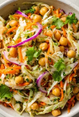 Cabbage Chickpea Salad with Carrot and Lime in a bowl garnished with lime wedges.