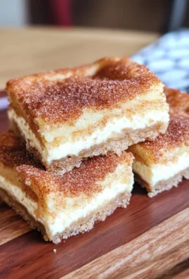 Delectable Churro Cheesecake Bars topped with cinnamon sugar