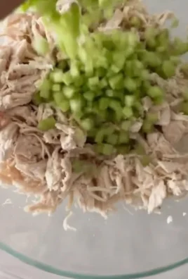 Bowl of classic chicken salad with fresh vegetables and dressing