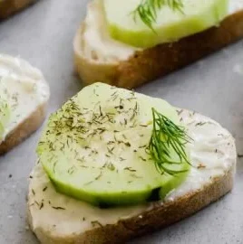 Cucumber cream cheese bites appetizer topped with herbs
