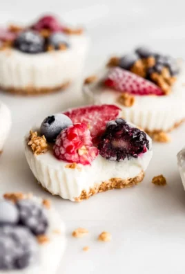 Frozen yogurt granola cups topped with fresh fruit and granola.