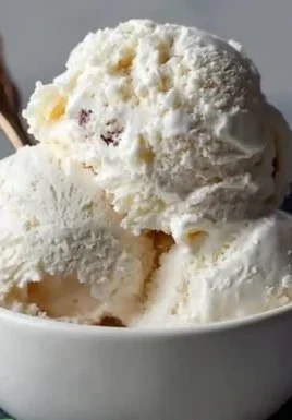 A bowl of homemade Greek yogurt ice cream topped with fresh berries.