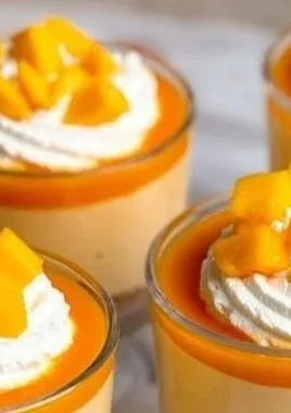 Homemade mango cheesecake cups topped with fresh mango slices