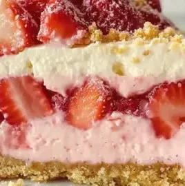 Delicious slice of strawberry shortcake cheesecake topped with fresh strawberries