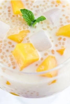 Delicious Mango Sago dessert topped with fresh mango slices and coconut milk