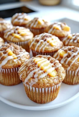 Freshly baked peach cobbler muffins topped with crumbly streusel.