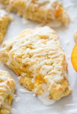 Freshly baked peach scones with chunks of peaches on a cooling rack