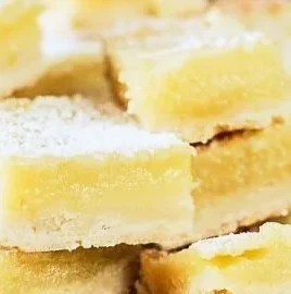 Delicious Pioneer Woman lemon bars topped with powdered sugar on a plate.