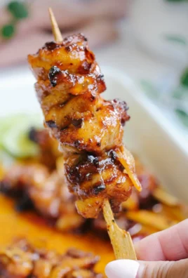 Plate of spicy honey chicken garnished with herbs and vegetables