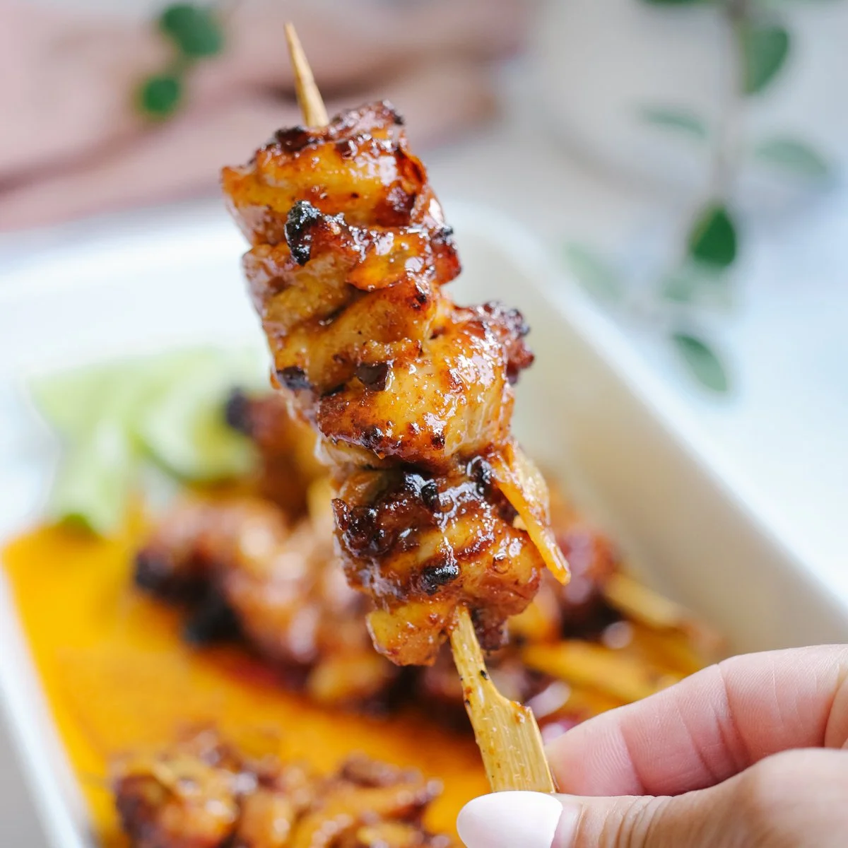Plate of spicy honey chicken garnished with herbs and vegetables