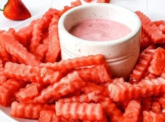 Watermelon fries served with strawberry yogurt dip in a colorful presentation