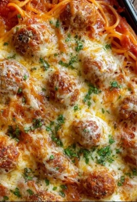 Dish of baked spaghetti and meatballs topped with melted cheese and herbs