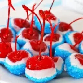 Boozy cherry bombs cocktail in a glass with cherries and drink ingredients