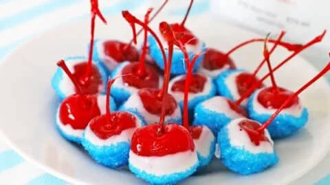 Boozy cherry bombs cocktail in a glass with cherries and drink ingredients