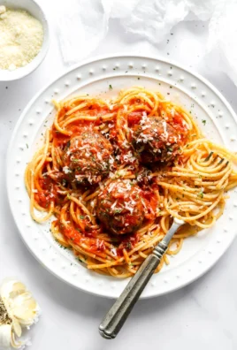 Plate of easy baked eggplant meatballs topped with sauce.