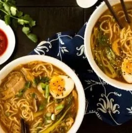 Bowl of easy chicken ramen garnished with green onions and boiled eggs