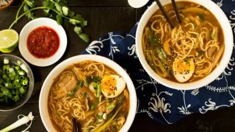 Bowl of easy chicken ramen garnished with green onions and boiled eggs
