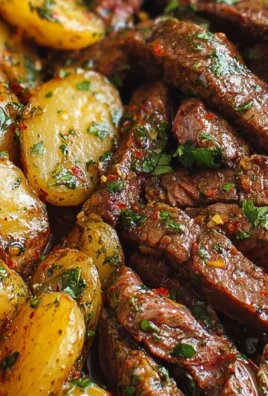 Garlic Butter Steak Bites served in a skillet with potatoes.