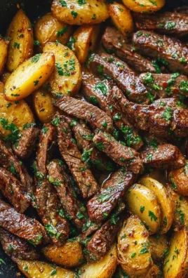 Garlic Butter Steak Bites with Potatoes Skillet on a rustic table