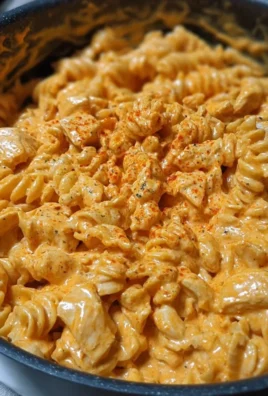 One-Pot Creamy Spicy Buffalo Chicken Pasta garnished with herbs