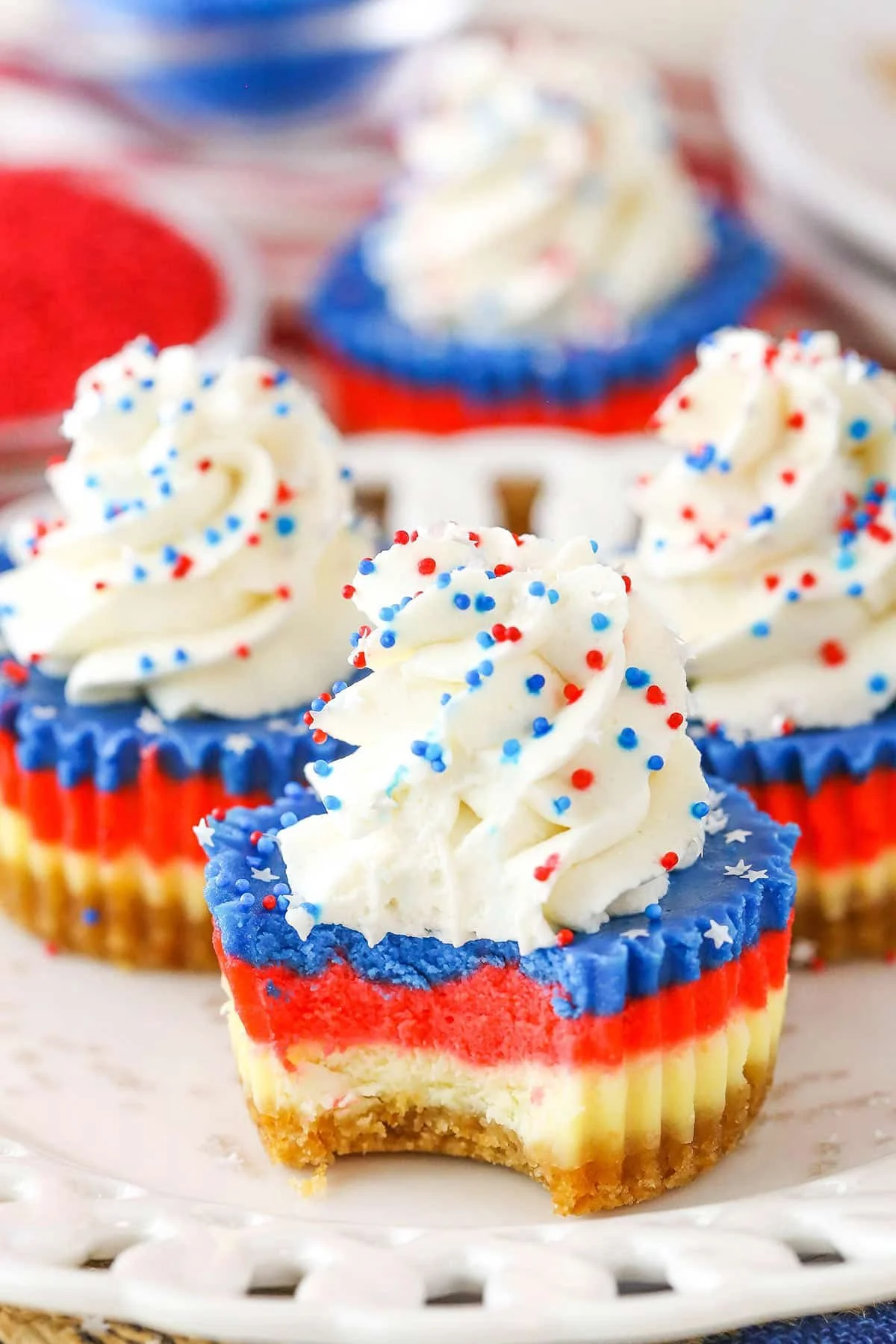 Red, White, and Blue Mini Cheesecakes topped with berries and cream