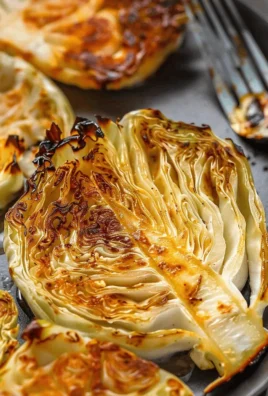 Roasted cabbage steaks on a plate with herbs and seasoning
