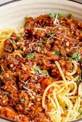 Delicious Vegan Lentil Bolognese served in a bowl with fresh herbs