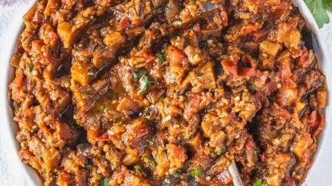 A bowl of Zaalouk, a Moroccan eggplant dip garnished with herbs.