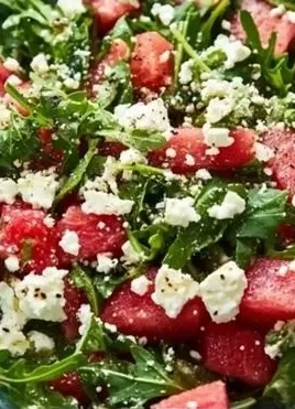 Fresh Arugula Watermelon Feta Salad garnished with mint and served in a bowl