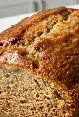 Slice of moist banana bread on a wooden cutting board