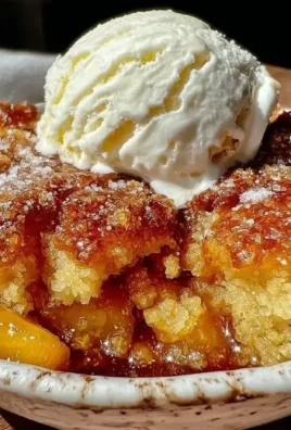 Brown butter peach cobbler served with a scoop of vanilla ice cream