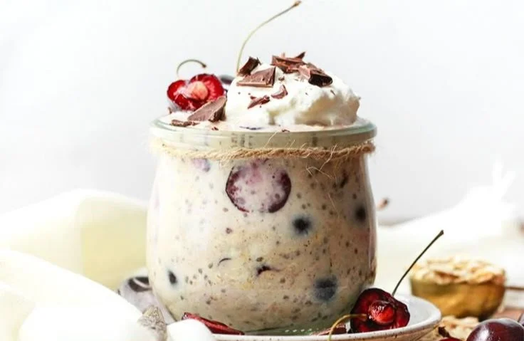 Cherry Chocolate Chunk Protein Overnight Oats in a jar topped with fresh cherries