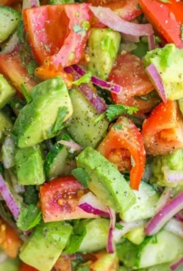 Bowl of Cucumber Tomato Avocado Salad garnished with herbs and spices