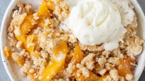 Delicious easy peach crumble dessert with golden crumble topping and fresh peaches.