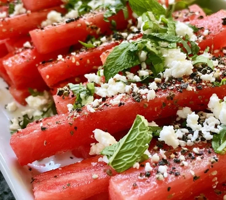 Epic watermelon fries topped with feta cheese and garnished for summer snack