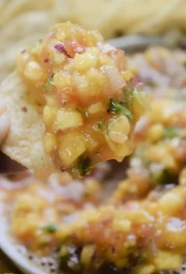 Bowl of fresh peach salsa made with ripe peaches, onions, and cilantro