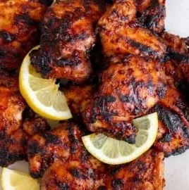 Juicy grilled BBQ chicken thighs on a barbecue grill