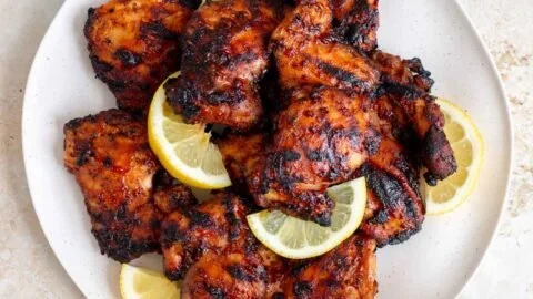Juicy grilled BBQ chicken thighs on a barbecue grill