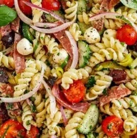Colorful Italian pasta salad with fresh vegetables and herbs in a bowl.