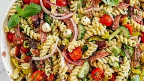 Colorful Italian pasta salad with fresh vegetables and herbs in a bowl.