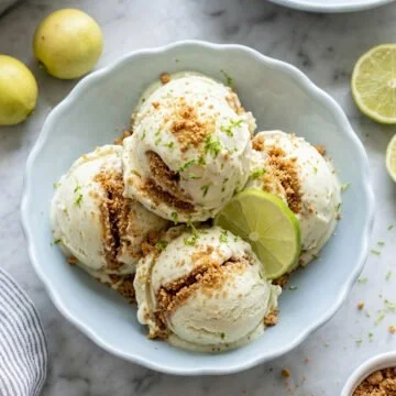 Delicious key lime pie ice cream served in a bowl with lime slices.