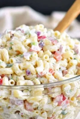 Delicious macaroni salad served in a bowl with fresh vegetables