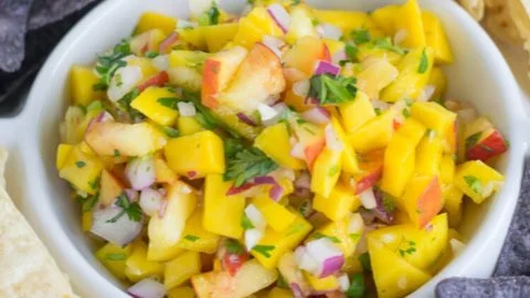 A bowl of colorful Mango Peach Salsa with fresh ingredients