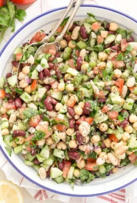 Colorful Mediterranean bean salad with fresh vegetables and herbs.