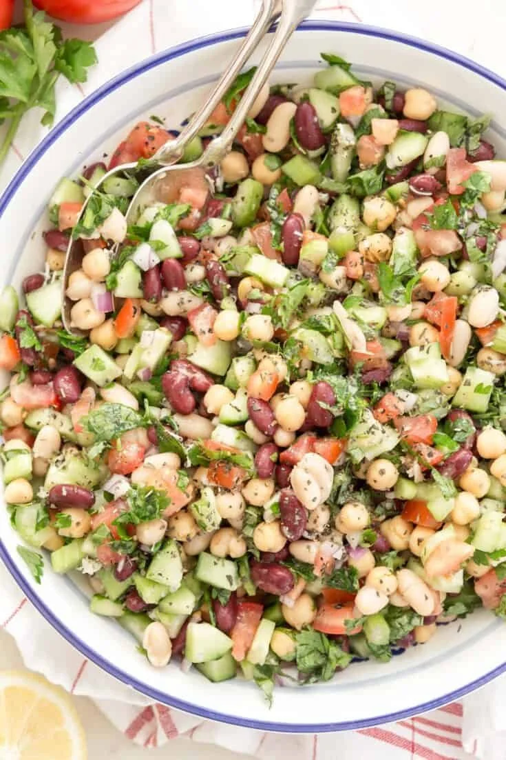 Colorful Mediterranean bean salad with fresh vegetables and herbs.